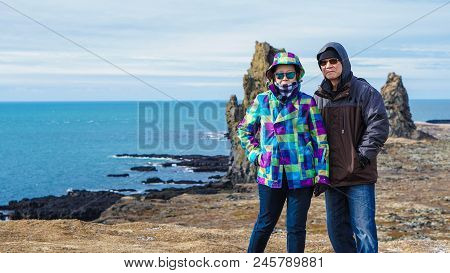 Asian Senior Couple Travel Photo With Iceland Pennisula Rock Landmark