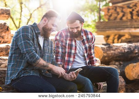 Smiling Bearded Lumberjacks Looking At Smartphone Screen