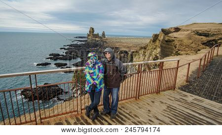 Asian Senior Couple Travel Photo With Iceland Pennisula Rock Landmark