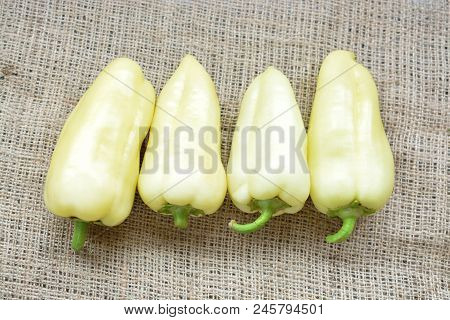 Four Green Peppers On A Brown Background. Fresh Organic Food. Vegetarianism.