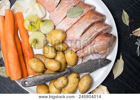 Fish Raw Snapper With Herb Spices For Fish In Glass Jar, Pepper, Bay Leaf, Celery On Dark Wood Backg
