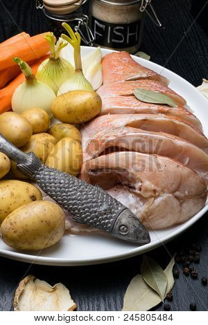Fish Raw Snapper With Herb Spices For Fish In Glass Jar, Pepper, Bay Leaf, Celery On Dark Wood Backg