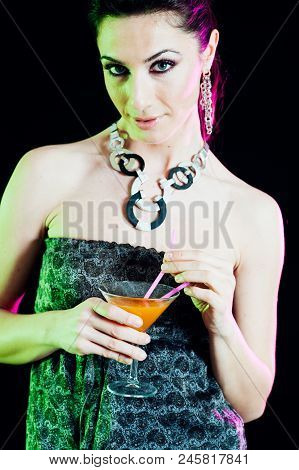 Young Caucasian Brunette Taking Aperitif With Black Background. Studio Shot