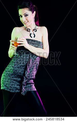 Young Caucasian Brunette Taking Aperitif With Black Background. Studio Shot