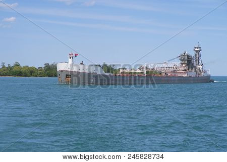 DETROIT RIVER, MICHIGAN - JUNE 14, 2018. The self-unloading cargo barge, Menominee, integrated with its tugboat, the Oliver Moore, enters the Detroit River from Lake St. Clair, both of which are part of the Saint Lawrence Seaway.