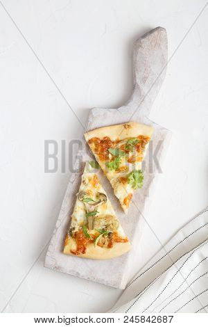 Two Pieces Of White Pizza With Artichoke And Arugula, White Background, Top View