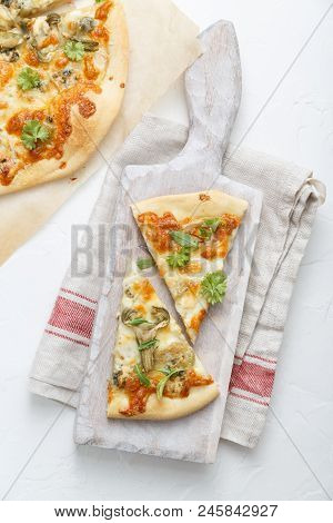 Two Pieces Of Pizza With Artichoke On White Cutting Board, Top View
