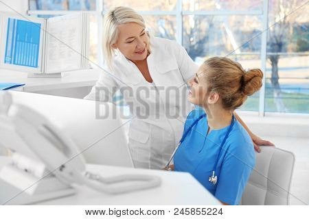 Female receptionist with trainee in hospital