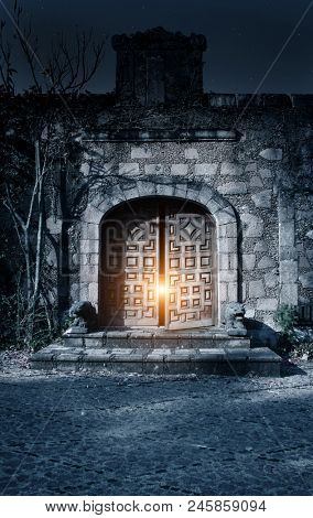 Horror in night. Light from the open door in medieval house