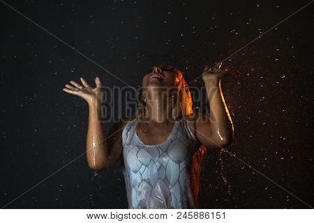 Nice Girl In The White Shirt And Water Drops Behind And Arround Her Illuminated By Light During A Ph