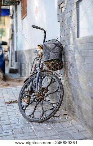 Beijing, China - March 10, 2016: Bicycles, Scooters And Cars In Beijing Streets. An Old Bike Is Plac