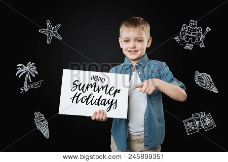 Hello Summer Holidays. Cheerful Little School Boy Pointing To The Sign Hello Summer Holidays And Fee