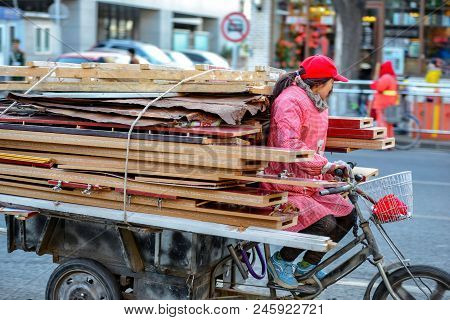 Beijing, China - March 10, 2016: People Are Driving Through The Streets With Bicycles, Scooters And 