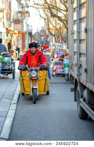 Beijing, China - March 10, 2016: People Are Driving Through The Streets With Bicycles, Scooters And 