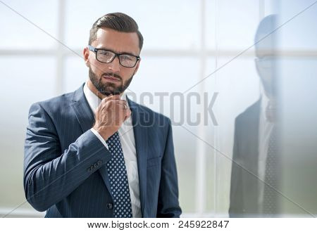confident businessman on background of office windo
