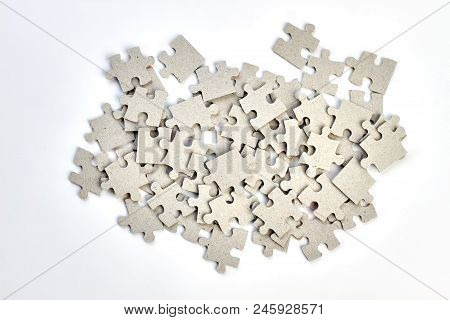 Heap Of Jigsaw Puzzles On White Background. Pile Of Uncompleted Puzzles Pieces Isolated On White.
