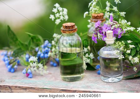 Essential Aroma Oil  In Bottles On Wooden Background Outdoor. Selective Focus. Natural Ogranic Produ