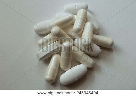 Handful Of White Capsules Of Magnesium Citrate And Caplets Of Calcium Citrate