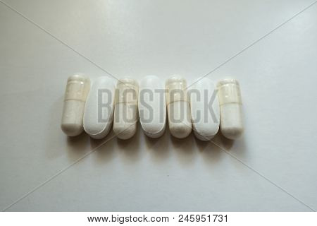 Veggie Caps Of Magnesium Citrate And Caplets Of Calcium Citrate In A Row From Above