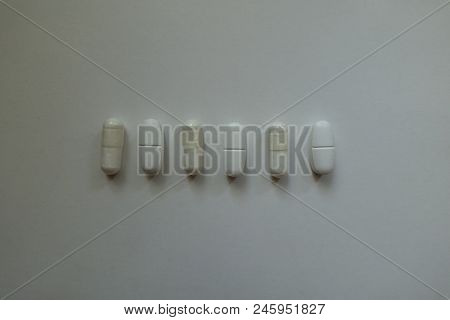View Of Row Of White Capsules Of Magnesium Citrate And Caplets Of Calcium Citrate From Above
