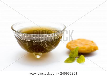 Jaggery Or Gud With Its Syrup In A Transparent Bowl Isolated On White.