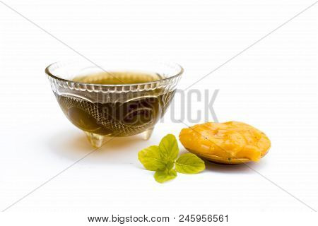 Jaggery Or Gud With Its Syrup In A Transparent Bowl Isolated On White.