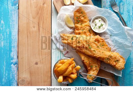 Traditional British Fried Fish In Batter With Chips In A Basket