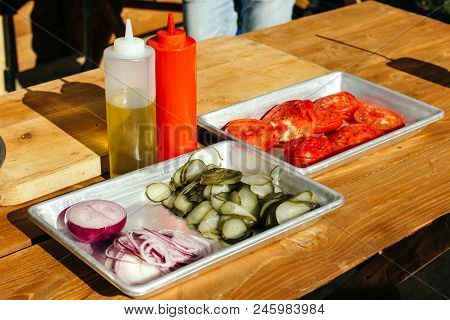 Sliced Cucumbers, Tomatoes In Aluminum Cuvettes. Ingredients For Assembling Hamburgers.
