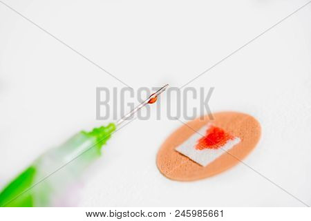 Drop Of Red Liquid On An Injection Needle And The Blood On The Plaster