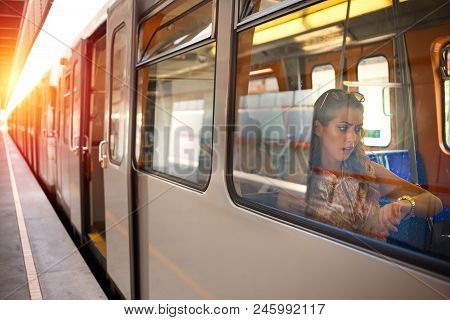 Beautiful Businesswoman Late For Work On The Subway Train Looking At Her Watch While Looking Concern