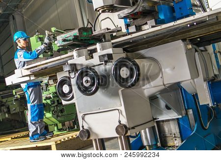 Heavy Duty Lathe Machinery Operator. Caucasian Metalworking Industry Worker In Front Of The Machine.