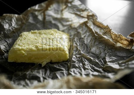 Soft Yellow Butter On The Wrapper And A Black Table. Crumpled Kraft Paper, Wrapping Paper, Greasy Oi