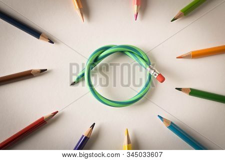 Colored Pencils With One Flexible Pencil On White Background. The Concept Of Flexibility In Decision