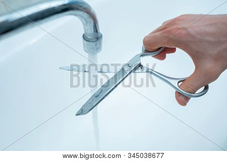 Stop Wasting The Pure Water, Hand With Scissors Cut The Water Stream From Faucet At Home, Environmen