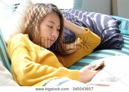 Young Asian Woman Using Phone While Lying On Sfa At Home, Asia Girl On Phone, People And Technology,