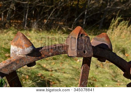 The Rusty Lugs Belong To A Steel Wheel Of An Old Tractor Used To Gain Greater Traction.