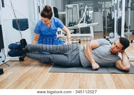 Kinesitherapist Training With A Male Patient Of Mixed Race. The Treatment Of Osteochondritis, Joint 