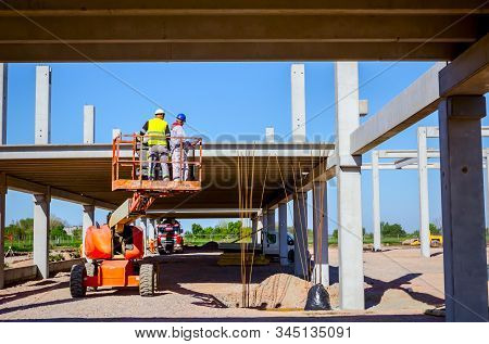 Rigger Is In High Elevated Cherry Picker, He Is Moving Over Construction Site.