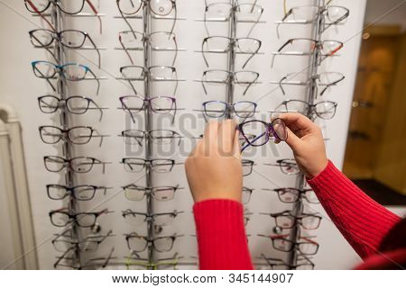Woman Choosing The Eye-glasses For Her Bad Eyes In Glasses Shop