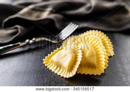 Italian stuffed pasta. Panzerotti pasta on black table.