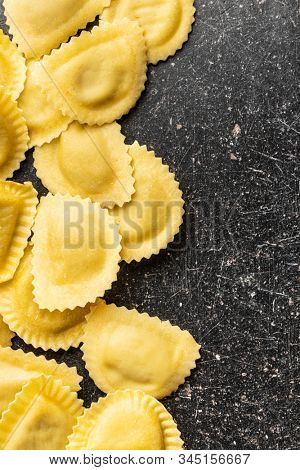 Italian stuffed pasta. Panzerotti pasta in bowl on old kitchen table. Flat lay.