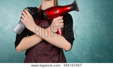 Hair Dryer And Spray Gun In The Hands Of A Hairdresser