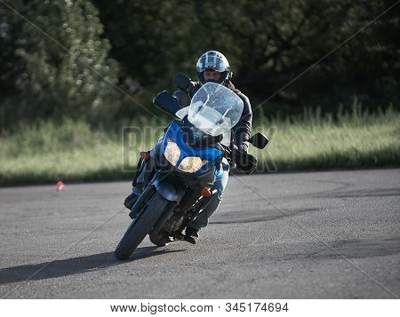 30-09-2019 Riga, Latvia. Motorcyclist On A Black Sports Motorcycle Rides On The Asphalt Ground