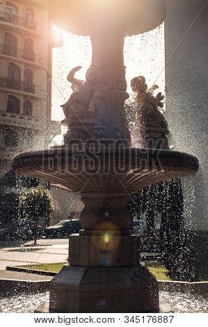 Drops Of Falling Water From A Sunny Back Light Fountain At City Park