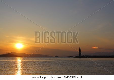 Seascape At Sunset. Lighthouse On The Coast. Seaside Town Of Turgutreis And Spectacular Sunsets