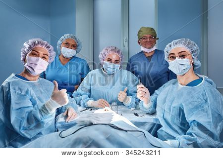 Group Of Professional Doctors Surgeons Over The Clinic Background In Oparation Room Smiling Looking 