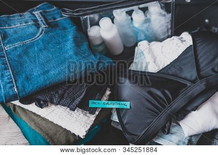 Luggage With Pile Of Clothes And Packing Everything Label On Them