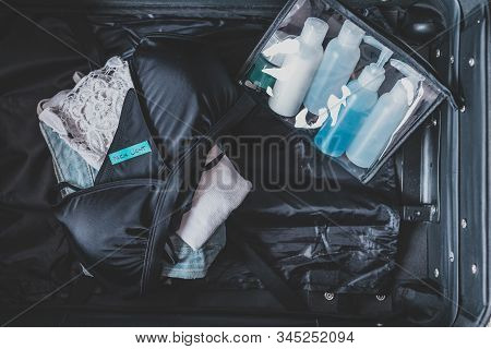Luggage With Few Items Inside And Packing Light Label On Them
