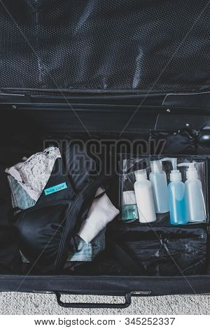 Luggage With Few Items Inside And Packing Light Label On Them