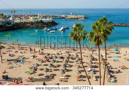 Canary Island Tenerife, Spain - 26 Dec, 2019: Tourists Are Relaxing On Playa La Pinta Puerto Colon. 